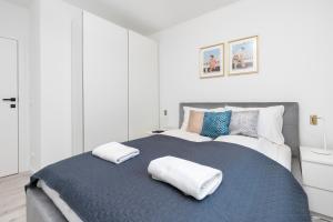 ein Schlafzimmer mit einem großen Bett mit zwei Kissen darauf in der Unterkunft Piastowska 30 Garden Free Parking by Renters Prestige in Przymorze
