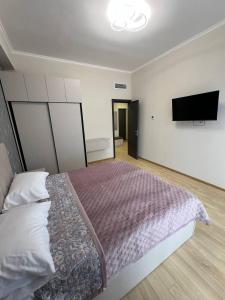 een slaapkamer met een bed en een flatscreen-tv bij Alvina complex in Tsachkadzor +2 foto's