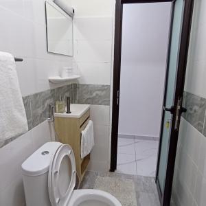 a bathroom with a toilet and a sink and a shower at Studio YaciAdjo in Abidjan