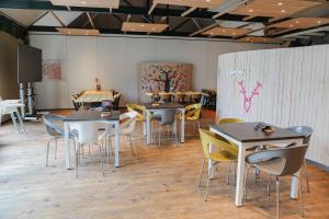 a dining room with tables and chairs in it at Chalet 4 persoons in Hoogersmilde