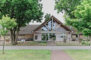 a house with a large window on the front of it at Chalet 4 persoons in Hoogersmilde