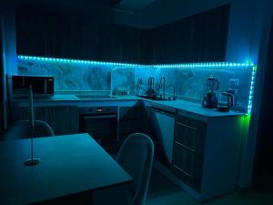 a kitchen with a blue led lighting and a table at Sea-View 1BR Apartment Balcony Full Kitchen Resort in Marsa Alam City