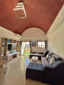 马萨阿拉姆Mazari的带沙发和砖砌天花板的客厅