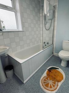 a bathroom with a tub and a toilet and a sink at Comfy Holiday Home & Beach Hut in Sutton on Sea
