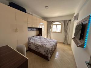 马萨阿拉姆Mazari的一间带床和电视的小卧室