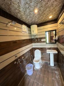 a bathroom with a toilet and a sink at River Bed in Vashisht