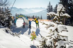 un groupe de personnes skier sur une piste enneigée dans l'établissement Carpe Solem Kaprun Apartments 4 stars by ALPS RESORTS, à Kaprun
