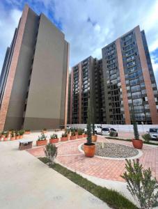 dos edificios altos con macetas en un patio en Moderno apartamento frente a viva mall, en Tunja