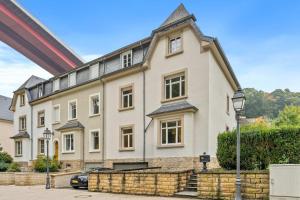 a large white building with a black roof at Charming Apartment in Historic Pafendall in Luxembourg