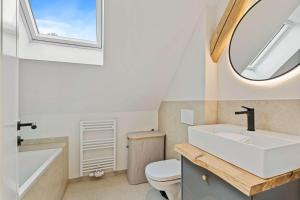 a bathroom with a sink and a toilet and a mirror at Charming Apartment in Historic Pafendall in Luxembourg