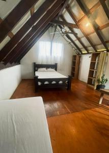 a large room with a bed in a attic at A nice rustic house to relax in Santo Domingo