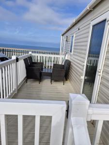 a deck with chairs and a balcony with the ocean at Sea veiw in Kinmel Bay +1 photo
