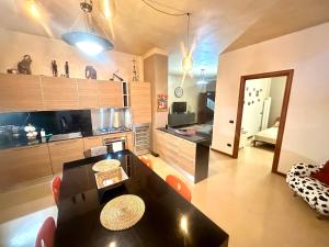 a living room with a table and a kitchen at Oasi di Monchiero in Monchiero