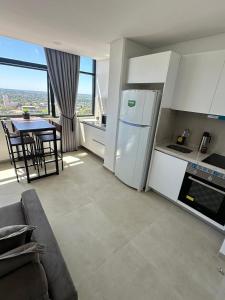 a kitchen with a white refrigerator and a table with chairs at Elegante, sofisticado, acogedor, moderno, turismo in Ciudad del Este