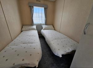 two beds in a small room with a window at Sea veiw in Kinmel Bay