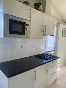 a kitchen with white cabinets and a black counter top at Bungalow 049 in Petten