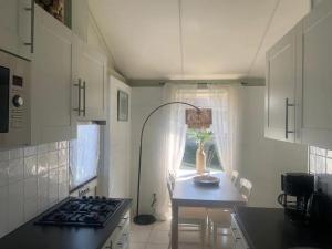 a kitchen with a stove and a table and a window at Bungalow 049 in Petten