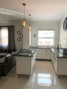 a kitchen with white cabinets and a counter top at Modern Apartment - Home away from home in Summerstrand