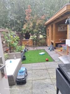 Un patio trasero con un pequeño jardín y un coche de juguete en Large family house in Tanthof, Delft, en Delft 4 fotos más