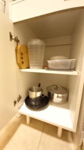 a kitchen shelf with pots and pans and dishes at Norita Alquiler Temporal - Departamento in La Rioja