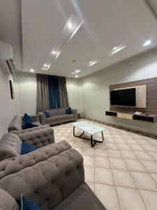 a living room with two couches and a flat screen tv at ليالي رهيف للشقق المخدومه in Abha +53 photos
