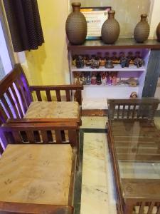 duas cadeiras de madeira dispostas em frente a uma prateleira com vasos. em Hotel White affordable Stay - Near Taj em Agra