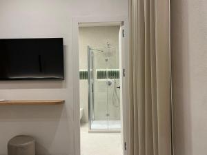 a bathroom with a shower with a glass door at Angilè Rooms in Agrigento +4 photos
