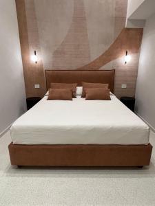 a bedroom with a large bed with brown pillows at Angilè Rooms in Agrigento