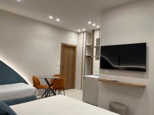 a hotel room with a bed and a table with chairs at Angilè Rooms in Agrigento