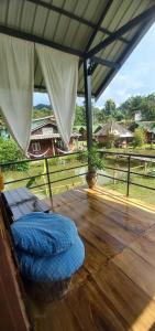 un lit sur une terrasse en bois avec vue sur un champ dans l'établissement Rainbow House Pai, à Pai