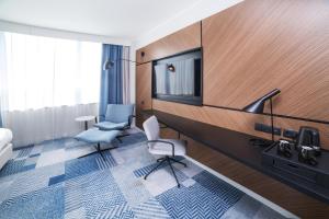 カトヴィツェにあるCourtyard by Marriott Katowice City Centerのテレビと椅子2脚が備わるホテルルームです。 +38枚の写真