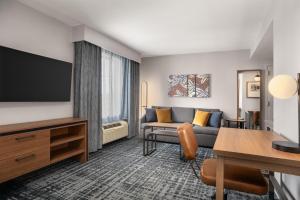 a living room with a couch and a flat screen tv at Homewood Suites by Hilton Newtown - Langhorne, PA in Newtown