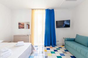 a living room with a couch and blue curtains at Appartamenti La Dimora di Parthenope Centro Storico in Naples