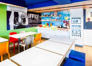a restaurant with tables and chairs and a refrigerator at ibis Budget - Melbourne Airport in Melbourne