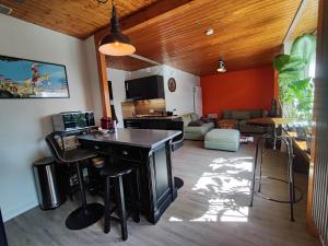 a living room with a table and a couch at Loc Aquatropic appartement de vacances in Bevaix