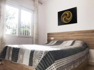 a bedroom with a bed with a wooden headboard and a window at Mary's house in Denia