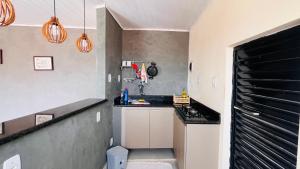 a small kitchen with a sink and a counter at Apartamento Aconchegante Perto da Dutra in Taubaté