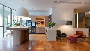 a kitchen with a island and chairs in a room at DoubleTree by Hilton Hannover Schweizerhof in Hannover
