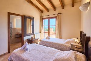 a bedroom with two beds and a window at Finca Hort Can Veritat in Cala Ferrera +51 photos