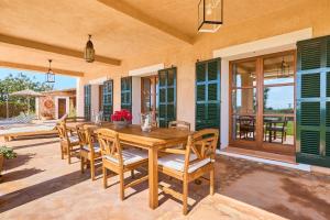 a wooden table and chairs on a patio at Finca Hort Can Veritat in Cala Ferrera