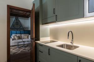 a kitchen with a sink and a living room at Apartamentos Gravina 31 in Seville +197 photos