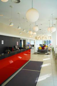 an office with a red and black reception desk at Golden Tulip Kassel Hotel Reiss in Kassel