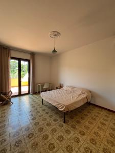 a bedroom with a bed and a large window at Villa with Garden near Rome for Groups & Families in Orte