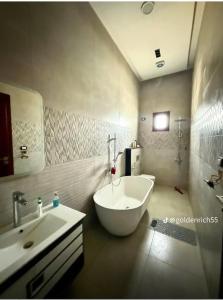 a bathroom with a large white tub and a sink at Reef Golden Resort شاليه الريف الذهبي in Qaryat ash Shamālī