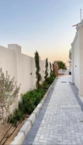 a stone walkway next to a white building at Reef Golden Resort شاليه الريف الذهبي in Qaryat ash Shamālī +7 photos