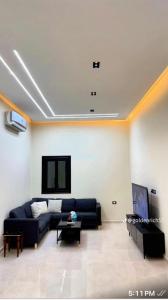 a living room with a couch and a tv at Reef Golden Resort شاليه الريف الذهبي in Qaryat ash Shamālī