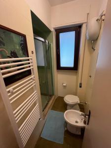 a bathroom with a toilet and a sink and a window at Villa with Garden near Rome for Groups & Families in Orte