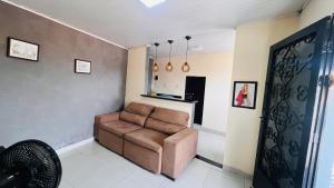 a living room with a brown couch in a room at Apartamento Aconchegante Perto da Dutra in Taubaté