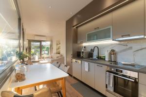 a kitchen with a white counter top and a table at Petrochori Beach House in Voidokilia