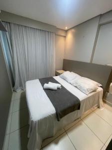 a bedroom with a bed with two towels on it at Beach Class Excelsior - Flat 1 quarto no Pina por Yolo in Recife